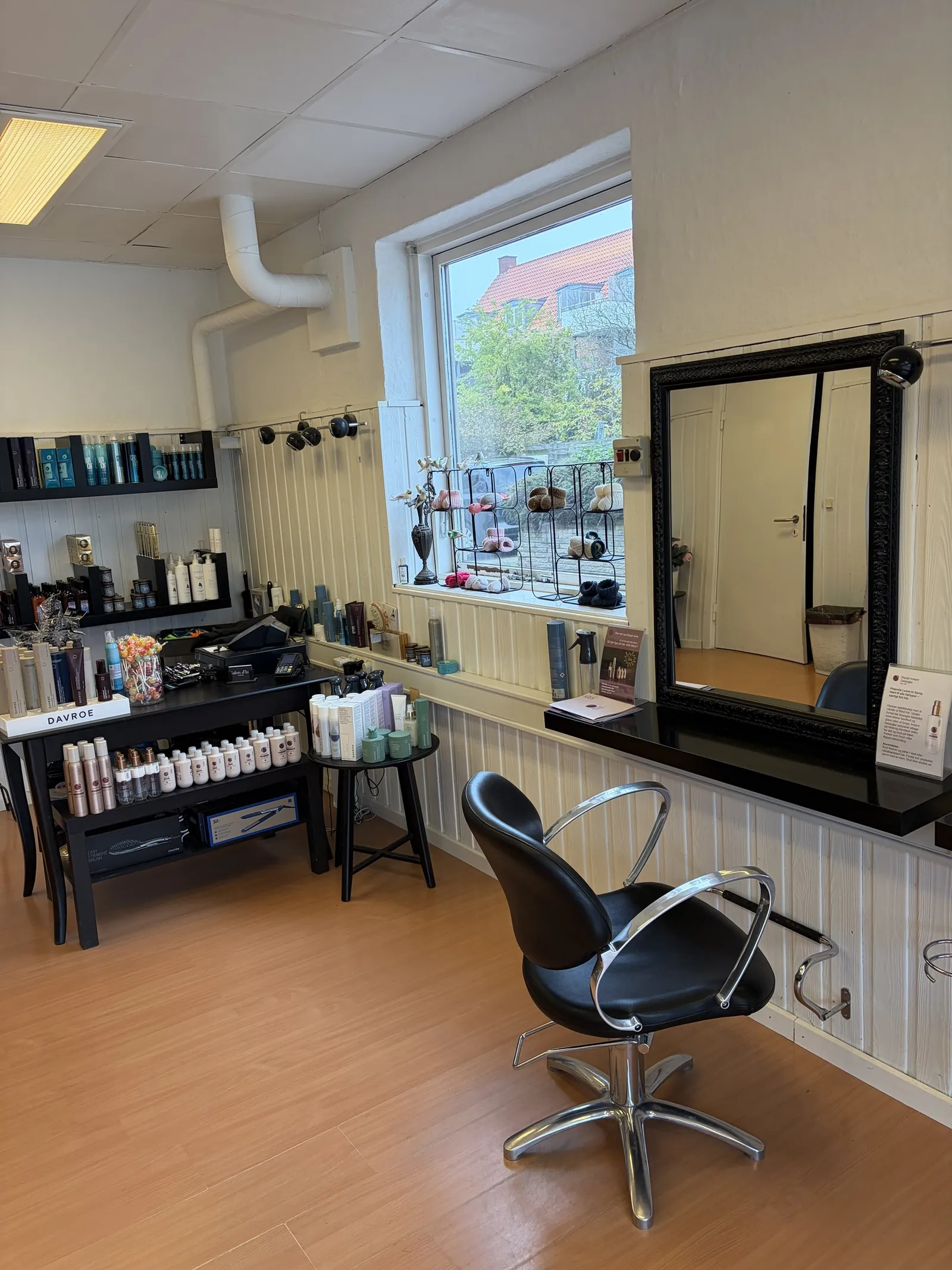Frisørstol og spejl ved vinduet i Salon d'Lux